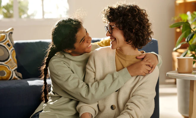 Daughter hugging mother and smiling