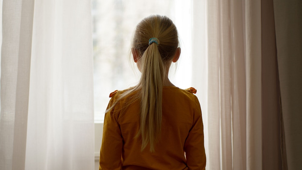 Young girl looking out a window