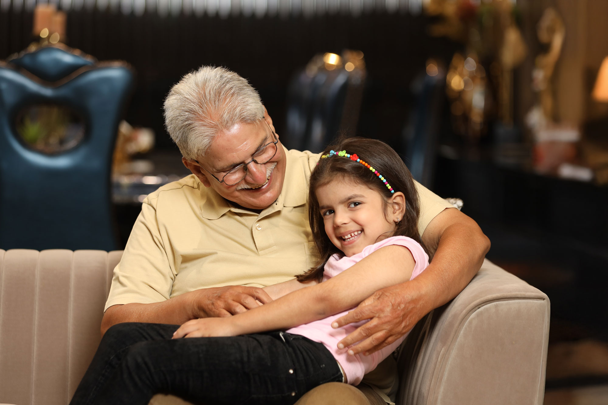 Smiling grandfather with his adopted granddaughter in his lap