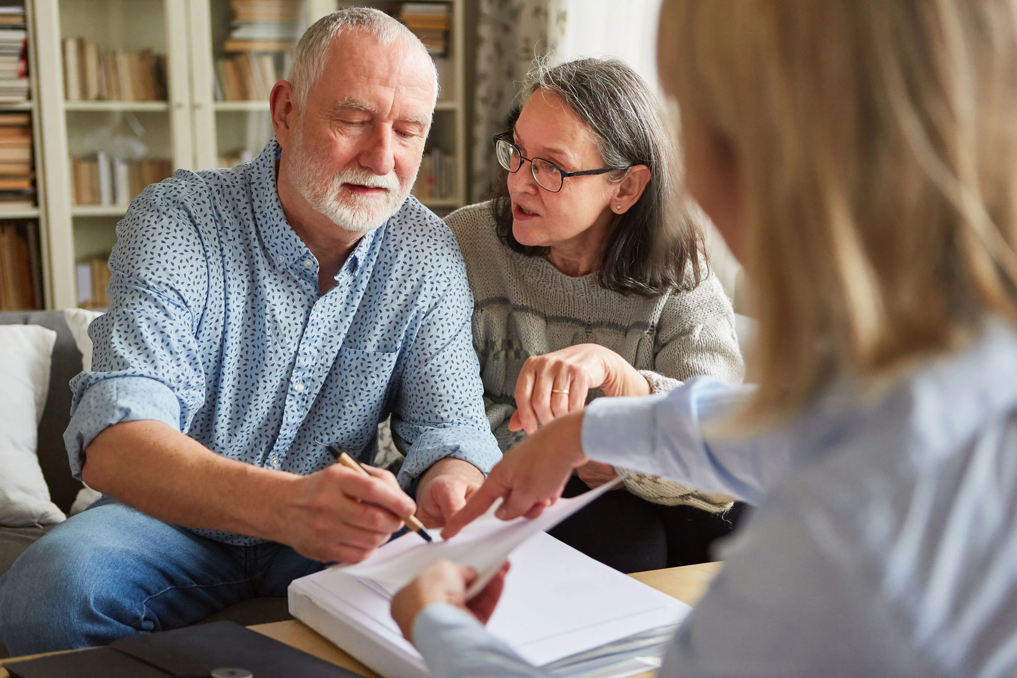 Older couple reviewing and signing prenuptial agreements