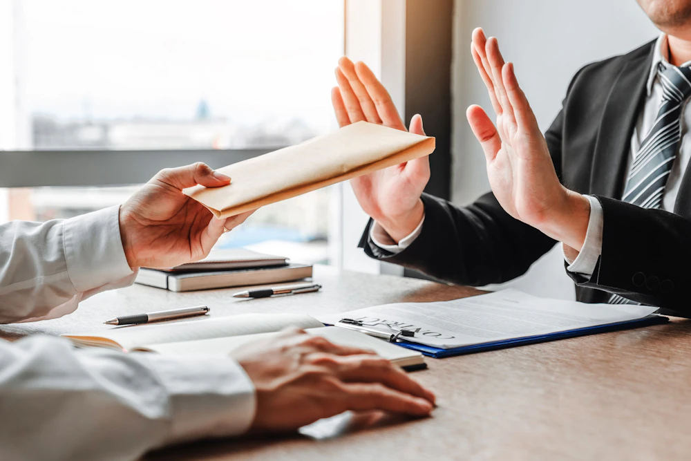 Someone refusing documents being handed to them at a desk