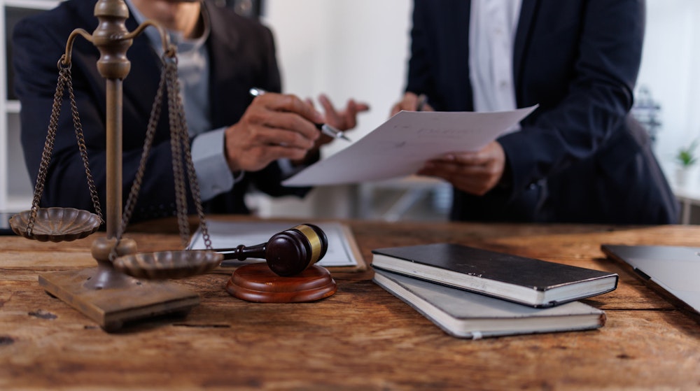 People reviewing document at desk with gavel