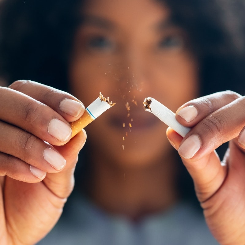Woman breaking cigarette in half