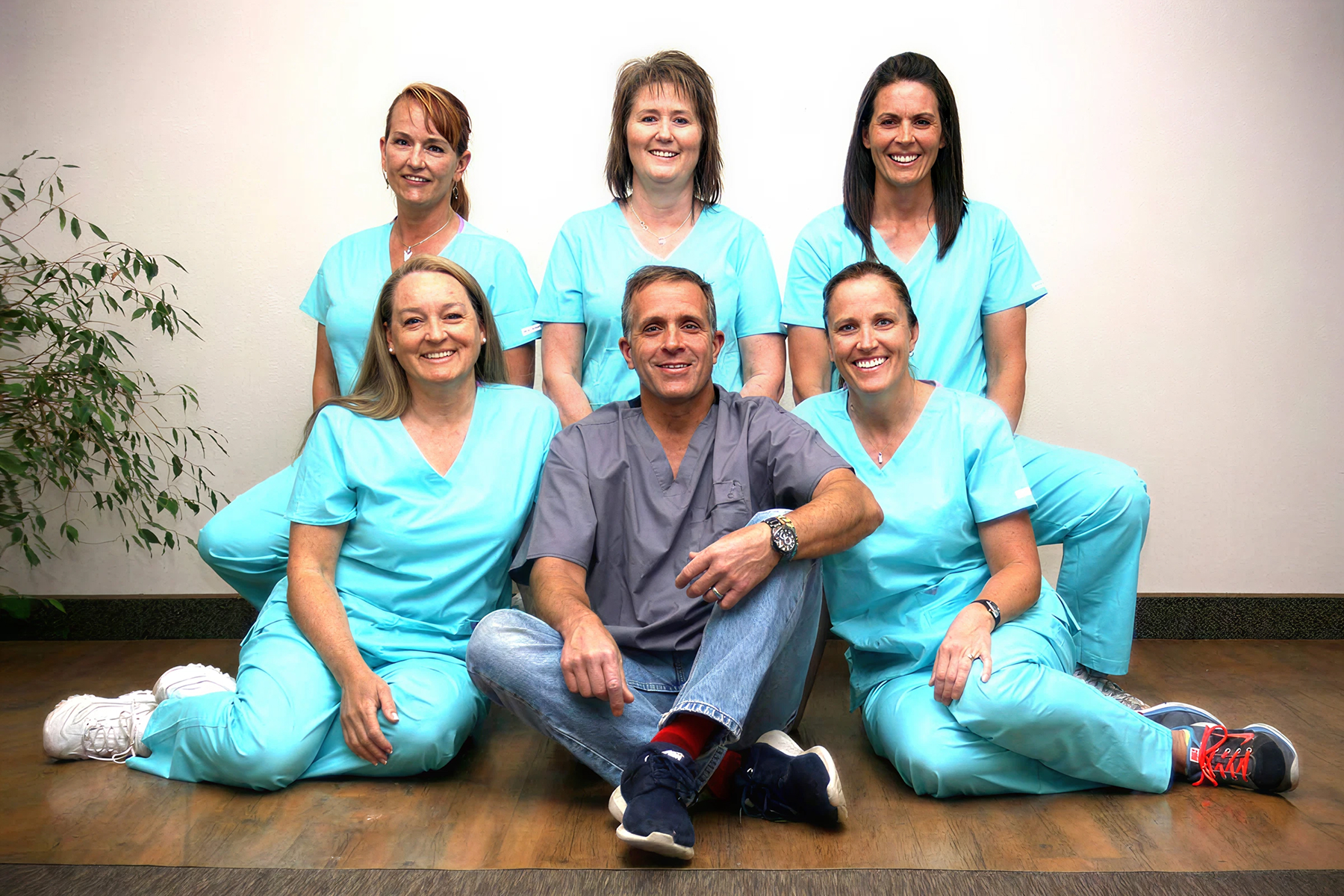 Dr. Tavoian sitting with his dental team in matching scrubs at their Cedar City office