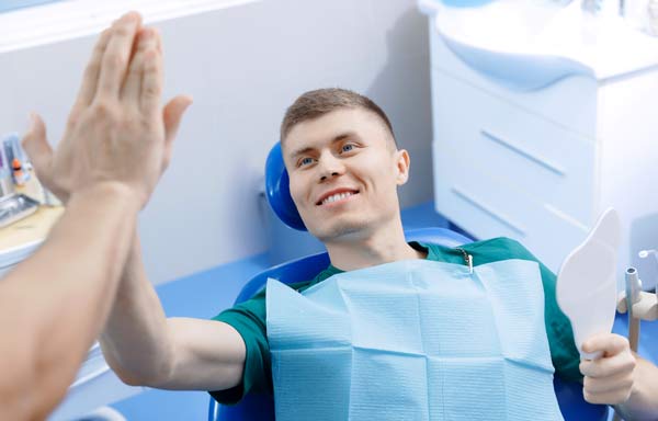 dental patient high-fiving a hygienist