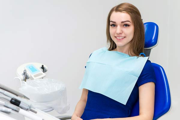 young woman sitting in dental chair smiling