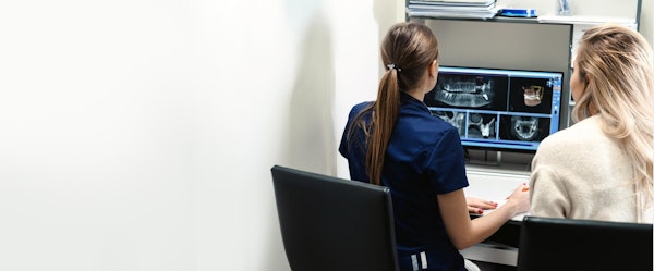 Dental technician showing patient the result of her x-rays