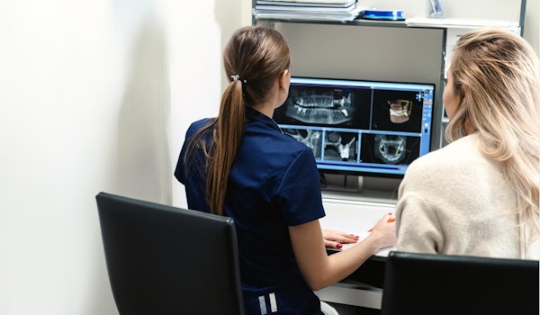 Dental technician showing patient the result of her x-rays