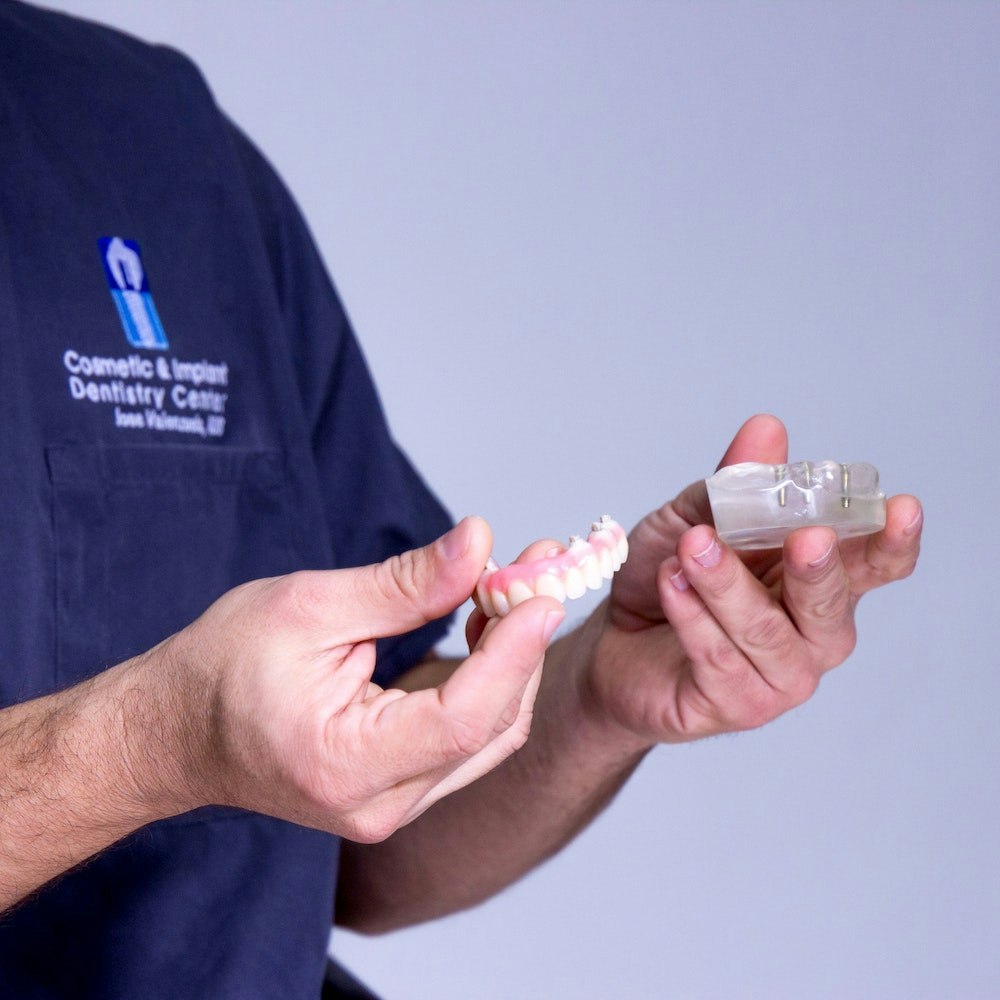 Dr. Valenzuela holding teeth models