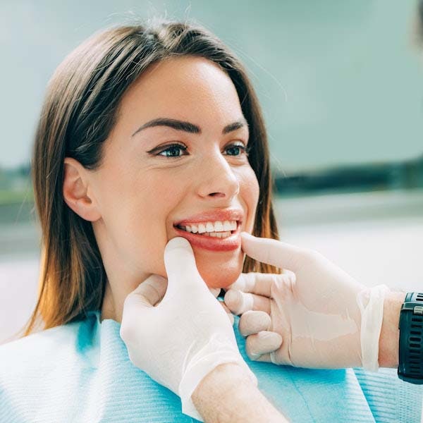 Dentist checking a woman's smile after treatment