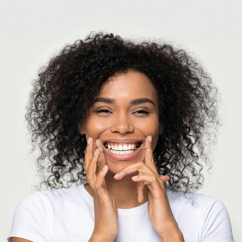 Woman flossing after a dental cleaning