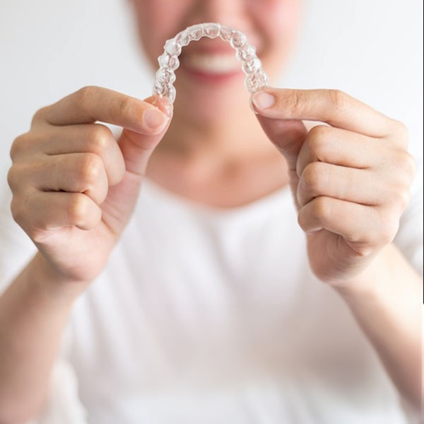 Person holding up an Invisalign aligner