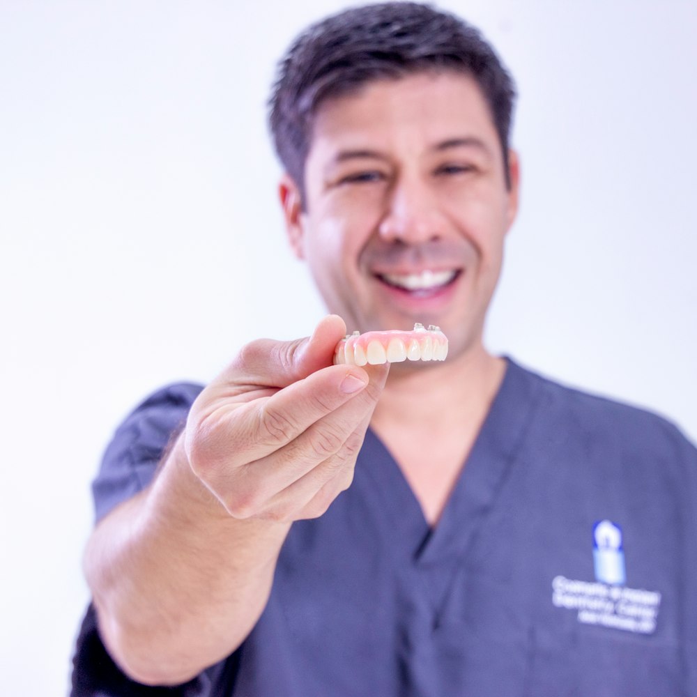 Doctor holding out an implant-denture