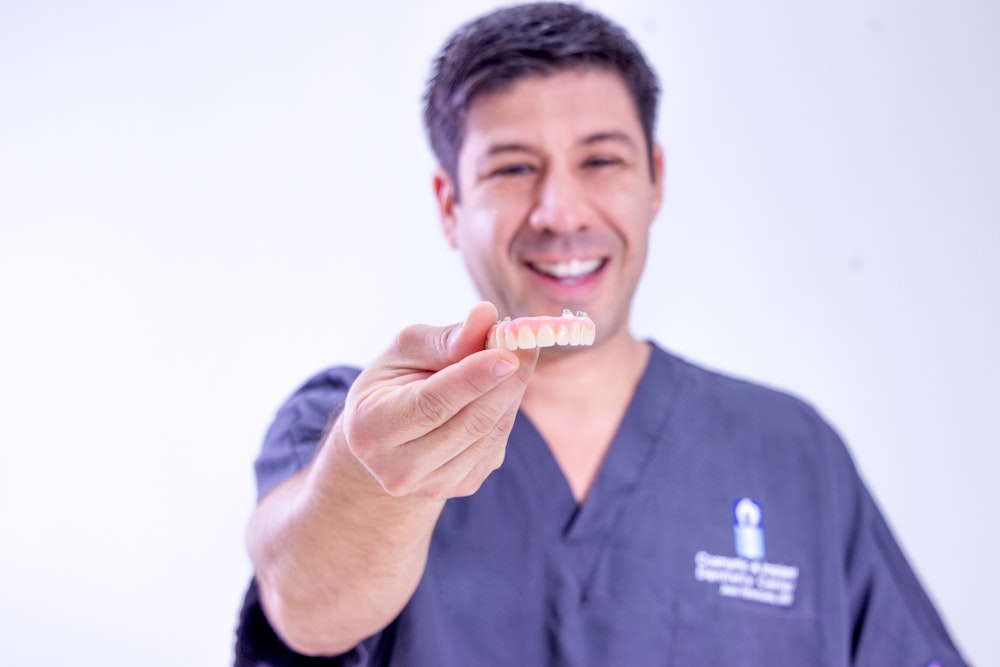 Doctor holding out an implant-denture