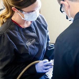 A hygienist and Dr. Andy Maples clean a patient
