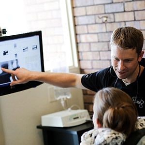Dr. Andy Maples points to a screen while speaking to a patient