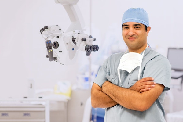 DR. Ravi Tandon standing next to the state-of-the-art breast reconstruction technology