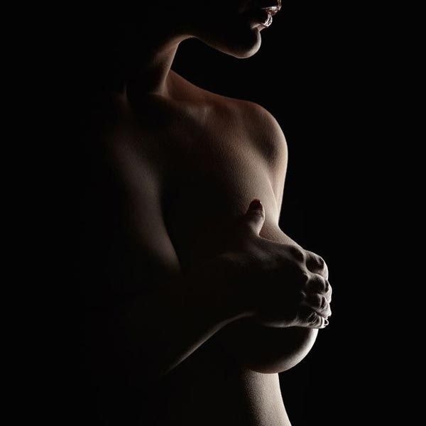 WOMAN COVERING BREAST WITH HAND