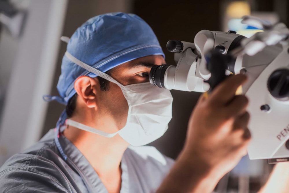 Dr. Ravi Tandon looking through a microscope