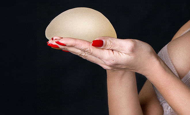 Woman holding breast implants