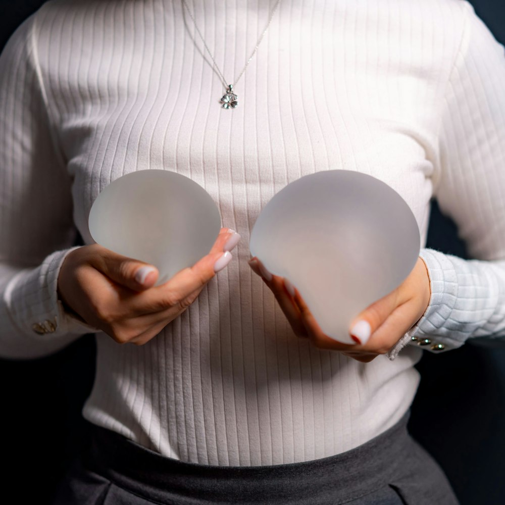 Woman holding up breast implants