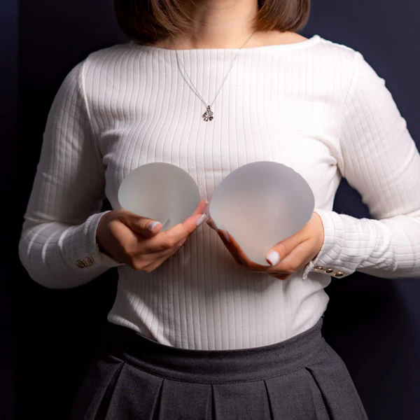 woman holding breast implants