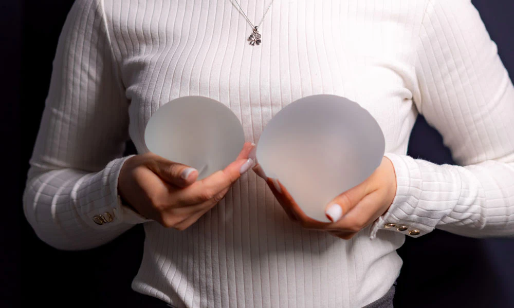 woman holding breast implants