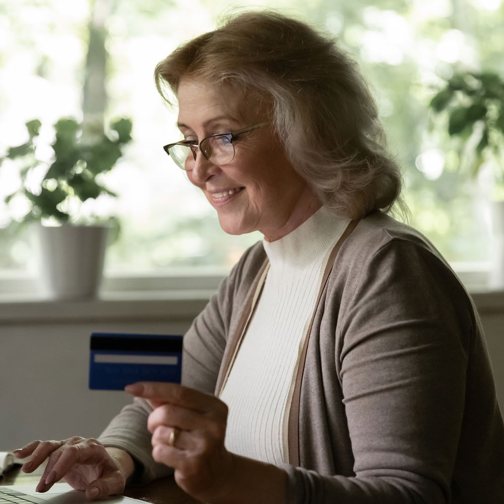 Mature woman paying for dental implants