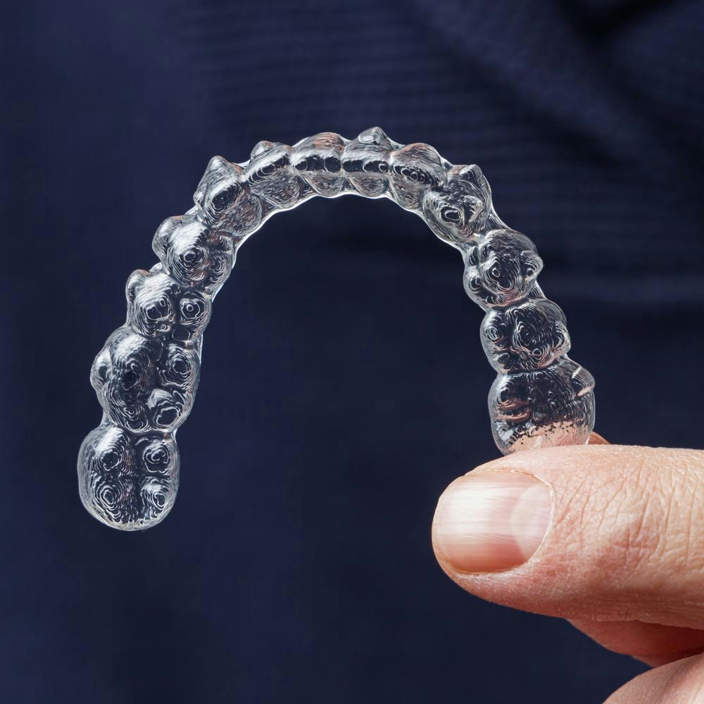 Person holding a clear aligner