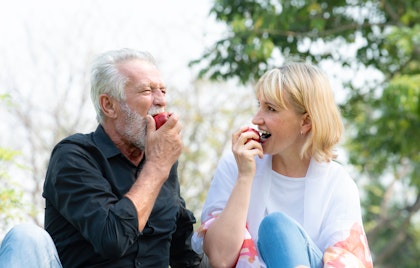 Mature couple on a picnic eating apples