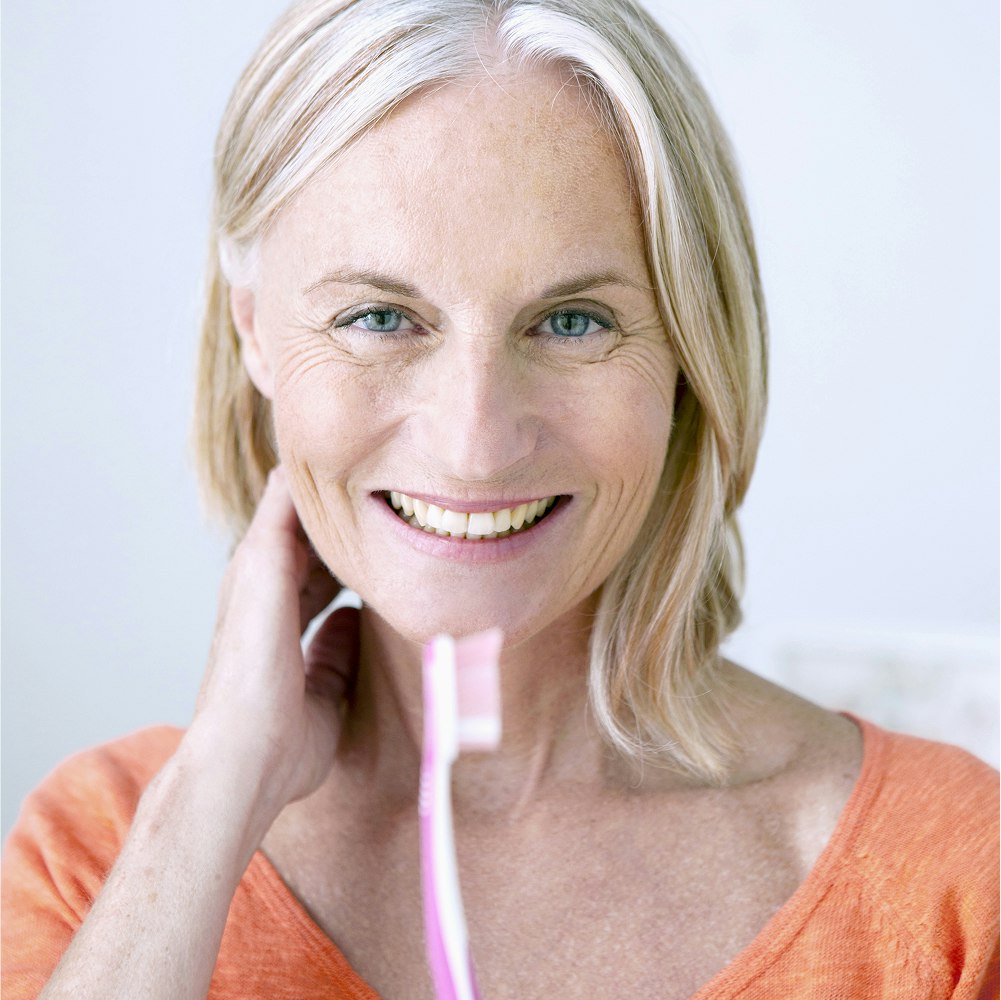 Smiling senior woman holding toothbrush
