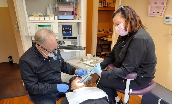 Dr. Gase and hygienist with patient