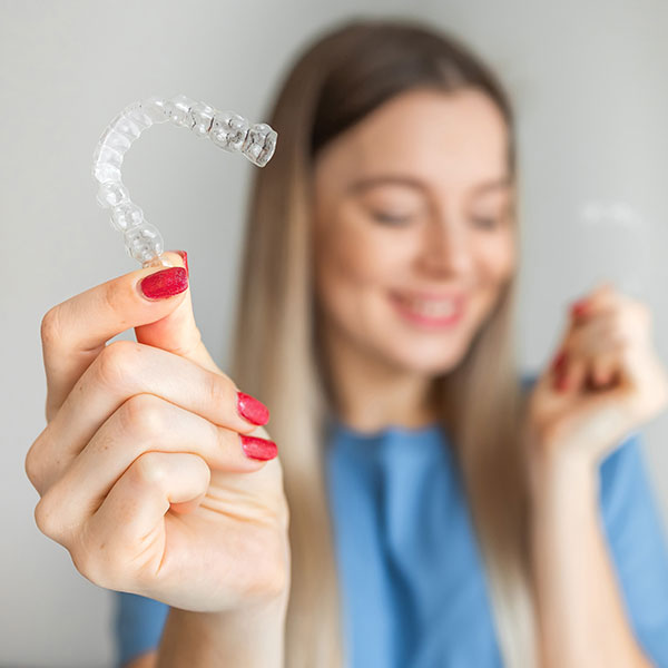Girl holding out Invisalign