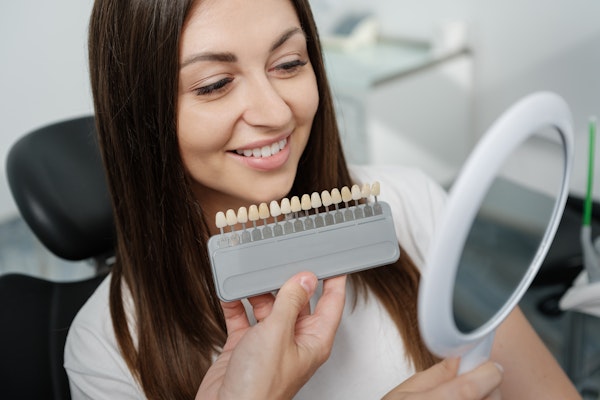 Woman getting shade matched for veneers