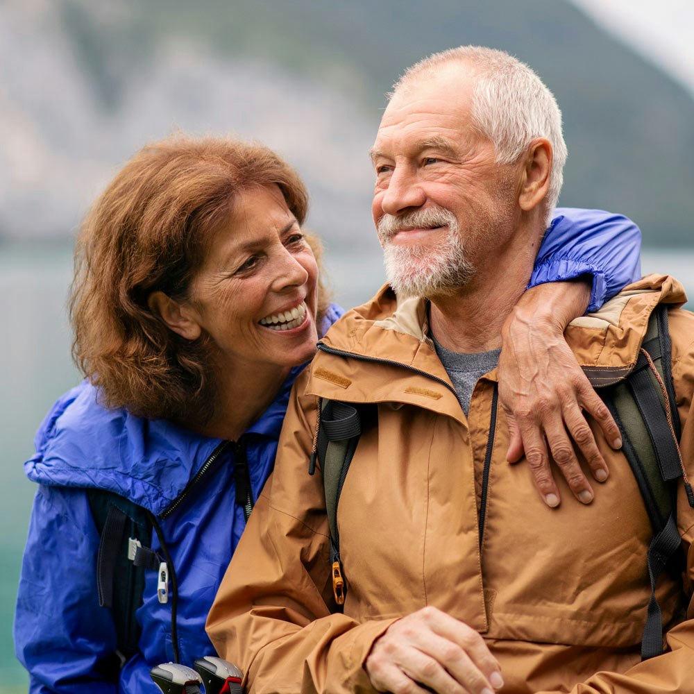 Couple smiling near a lake after hike