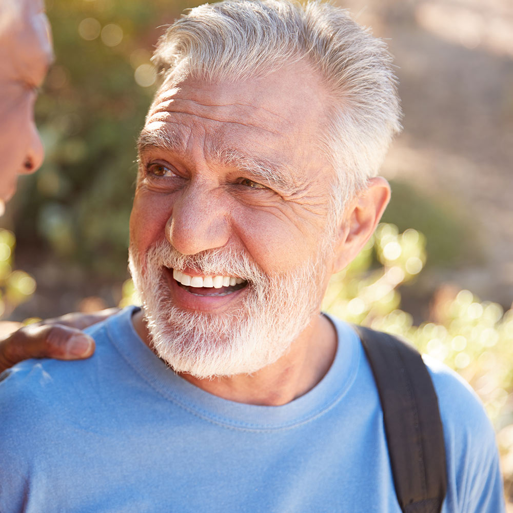 Mature man smiling at friend after glaucoma procedure