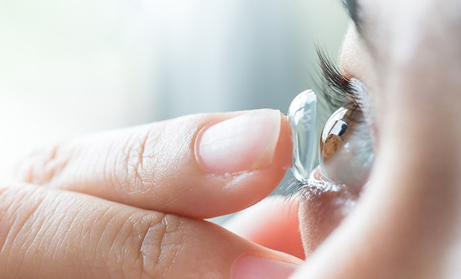 Woman placing contact for keratoconus in her eye