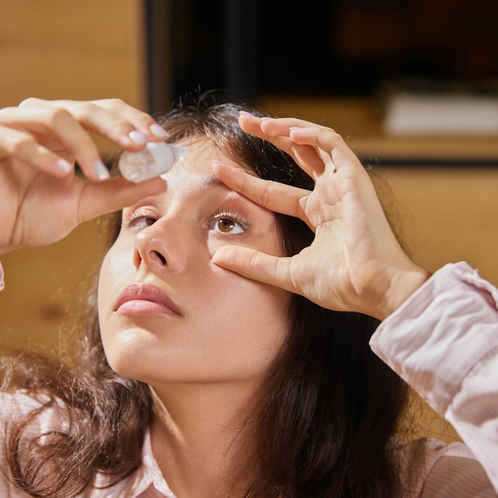 Teenage girl putting drops in her eyes