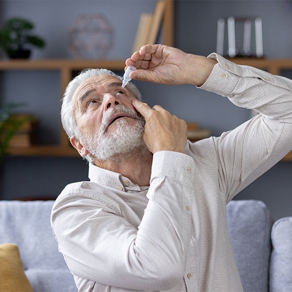 Senior man placing eyedrops