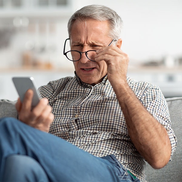 Man struggling to read in a well-lit room