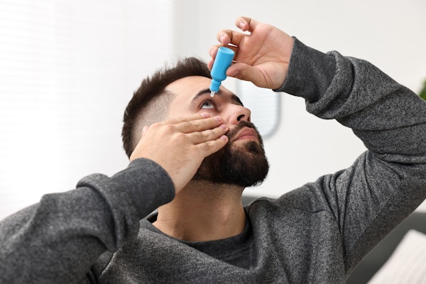 Man placing eye drops