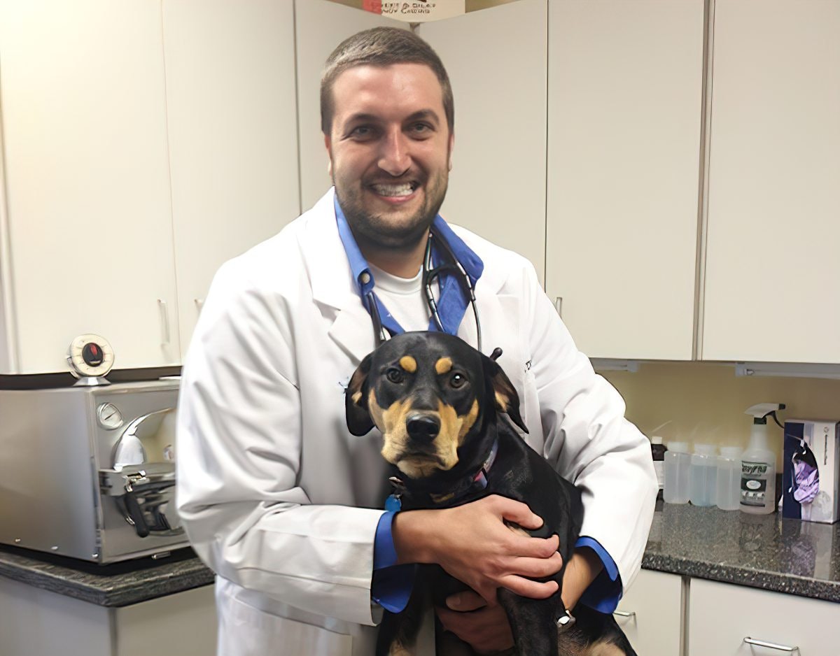 Julian Peckich hugging dog on exam table