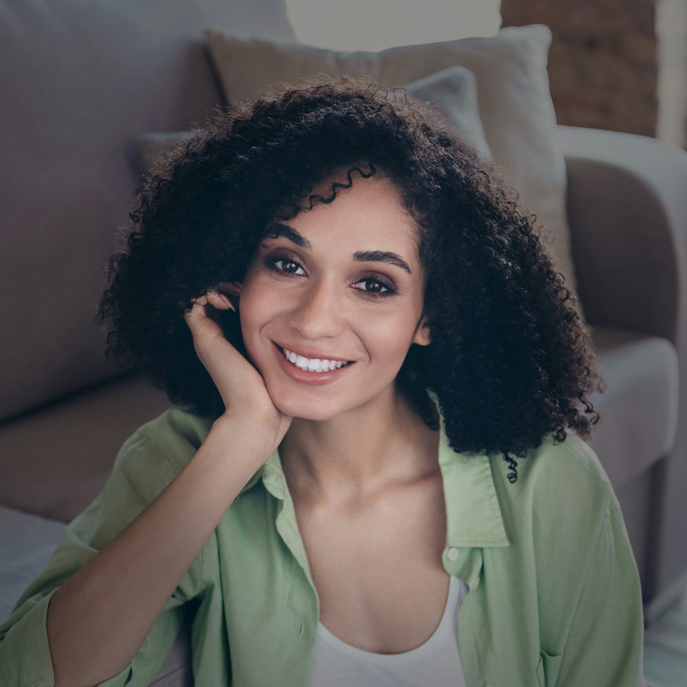 Smiling woman touching jaw after TMJ treatment