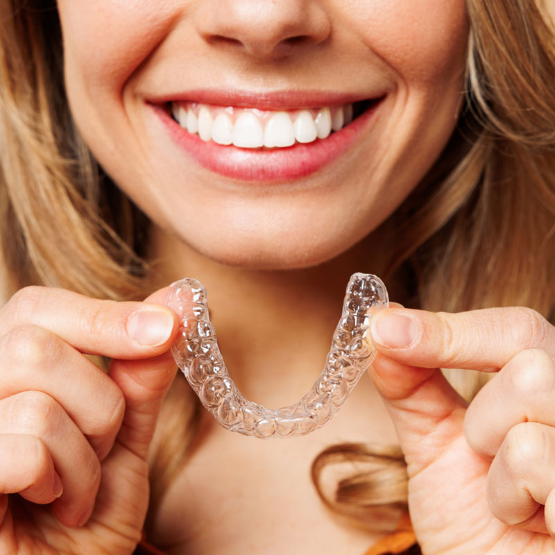 Woman holding clear aligner