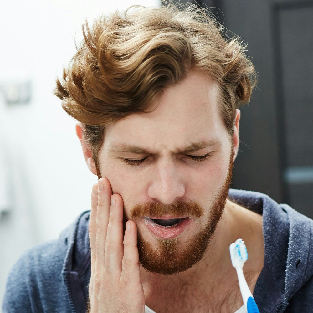 Man touching painful tooth