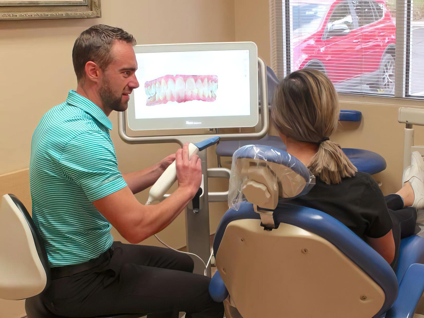 Dr. Ollason showing digital scanner X-ray to patient