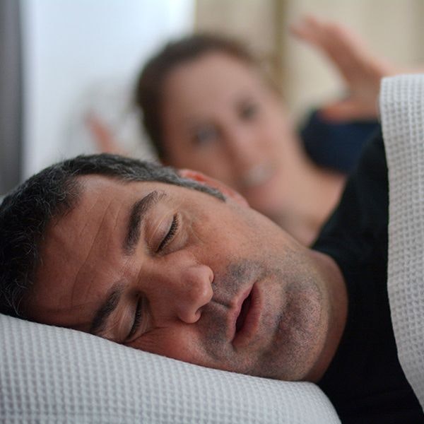 Man snoring, with upset woman in the background