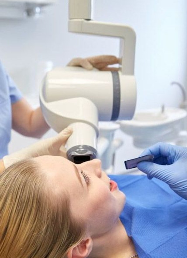 Technician taking digital impressions of patient's teeth