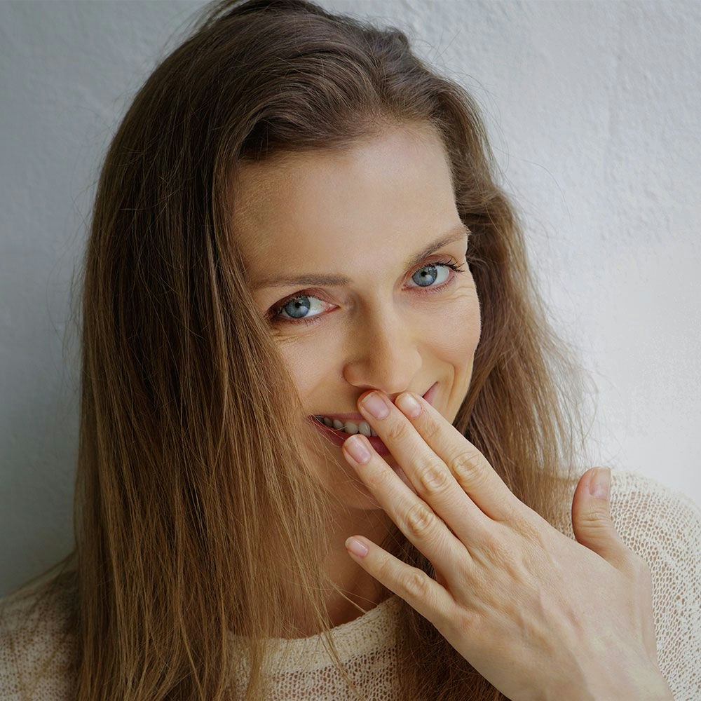 woman covering her smile