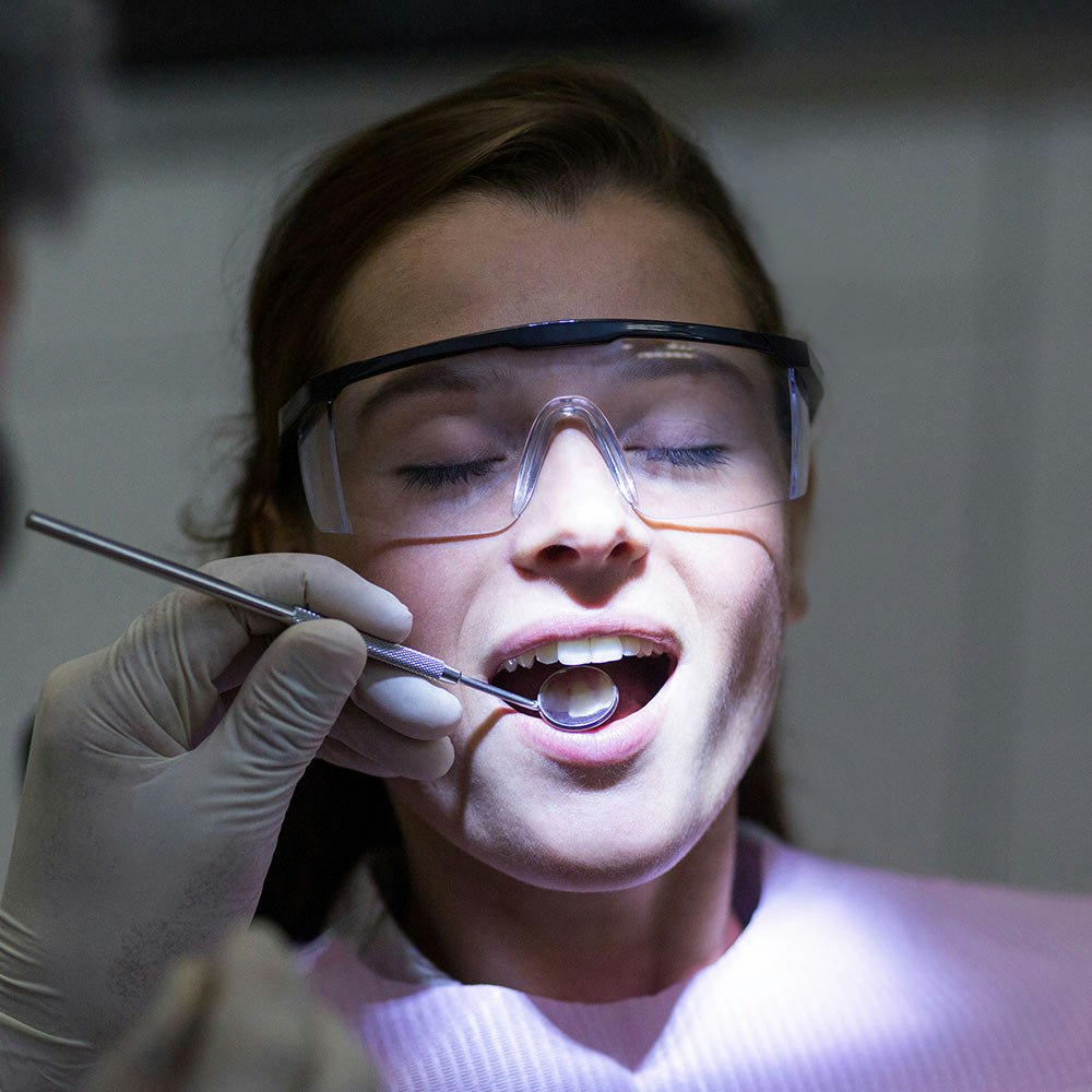 Young woman under sedation getting teeth checked